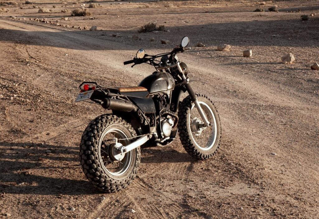 Uma moto customizada no estilo scrambler no deserto